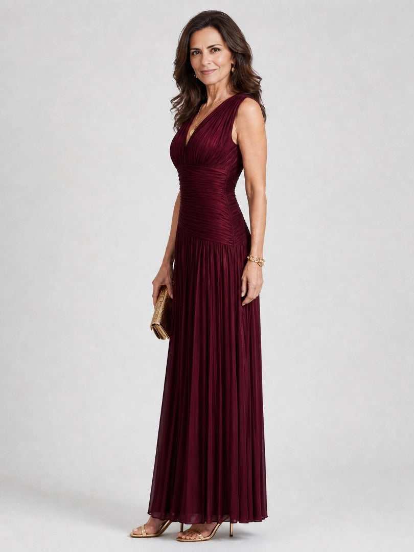 Side view of Vedress burgundy mother of the bride dress showing the draped V-neckline, ruched waist and flowing pleated skirt.